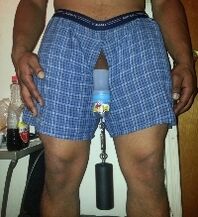 Un método traumático para agrandar el pene colgando una pesa.